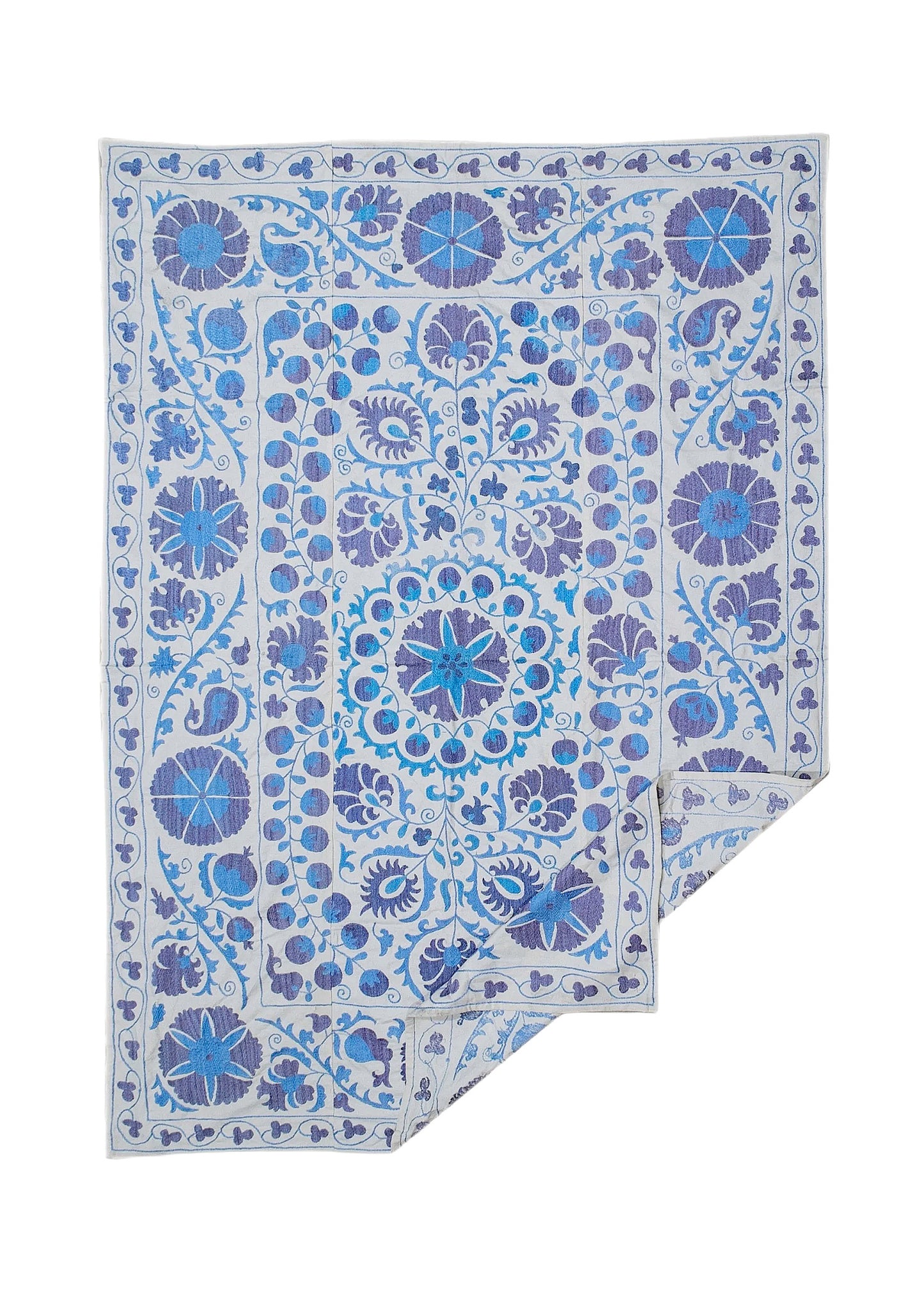 An Uzbek Suzani textile featuring intricate blue floral and botanical embroidery on a cotton base.