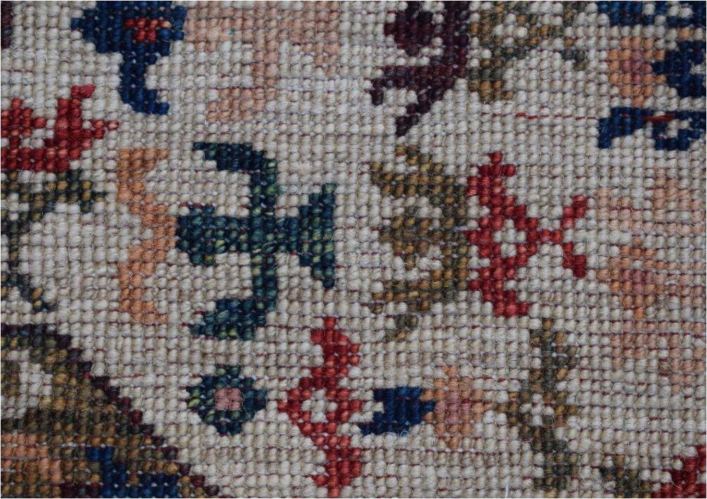 A close-up of a handmade Afghan Chobi runner featuring intricate geometric and floral motifs.