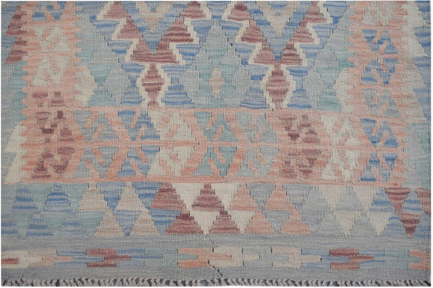 Handmade Afghan Maimana kilim runner featuring a geometric pattern in blue, pink, and cream wool.