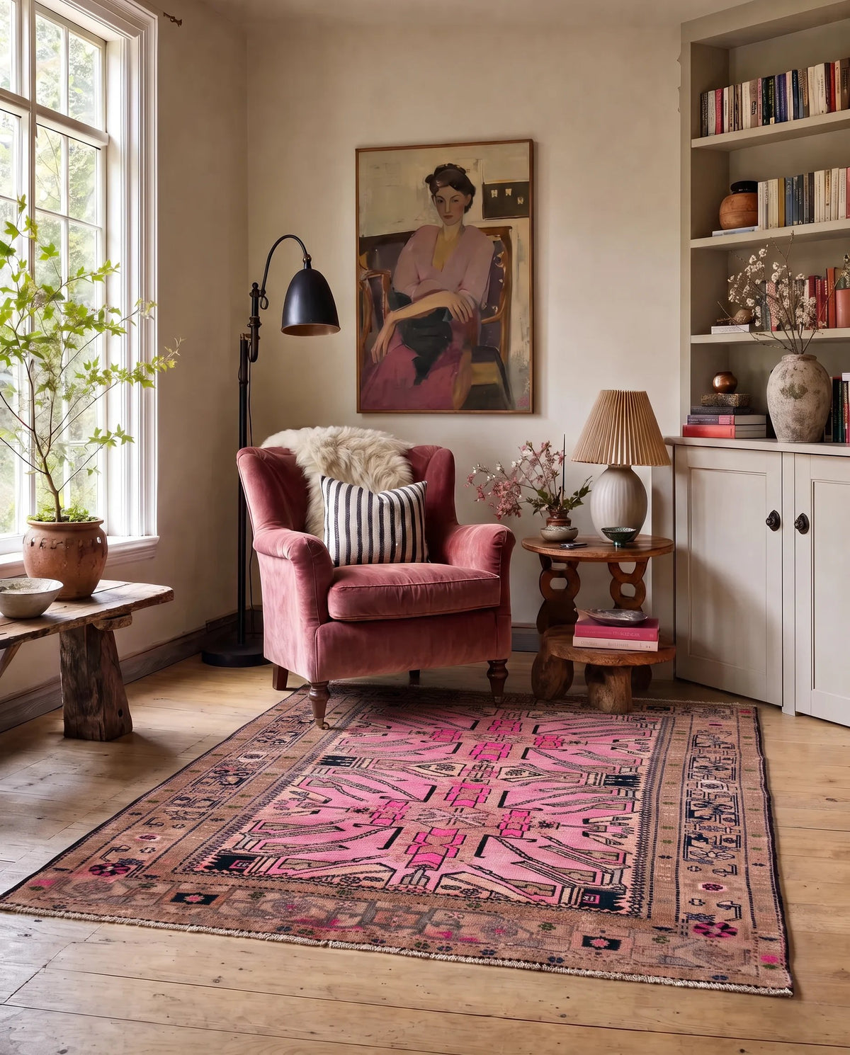 Vintage Caucasian Kazak rug with bold pink and dark geometric medallions on a faded brown field in a styled living room.