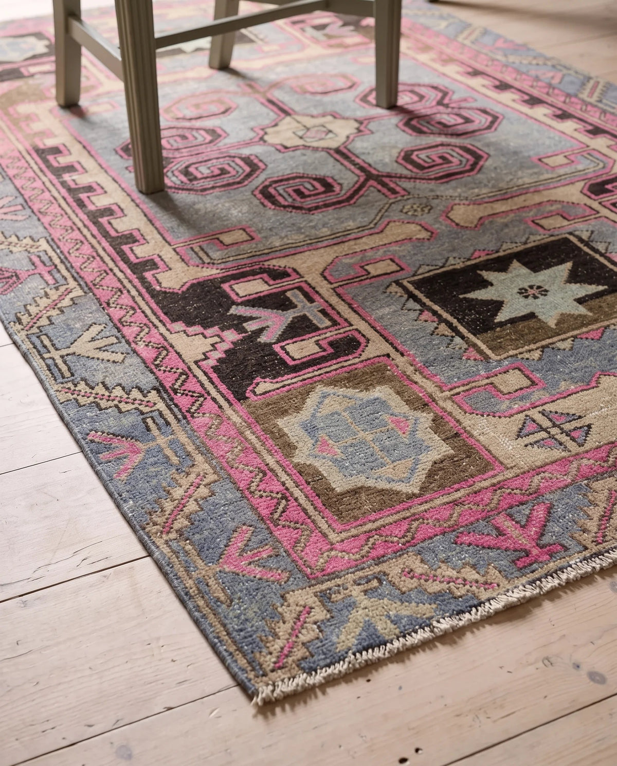 Hand-knotted vintage Hamadan rug with pink and blue geometric medallions on a timber floor.