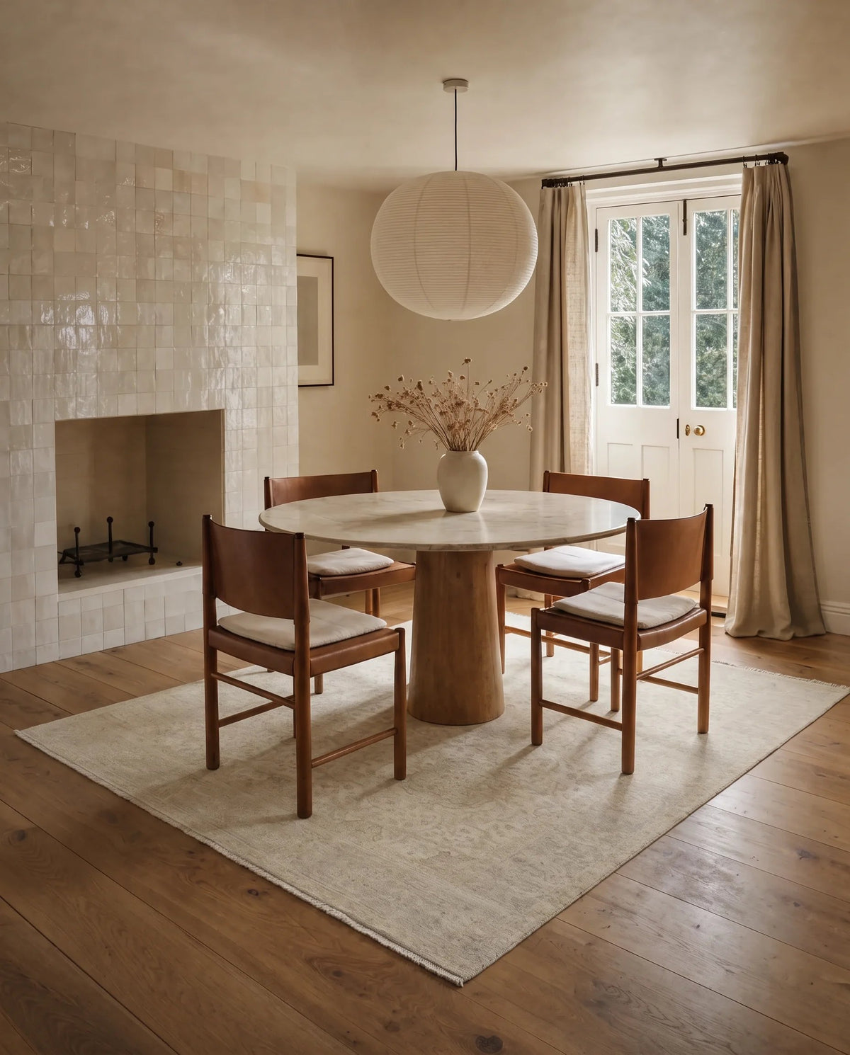 Hand-knotted Afghan Balkh rug in a neutral tone, styled under a round marble dining table in a light-filled room.