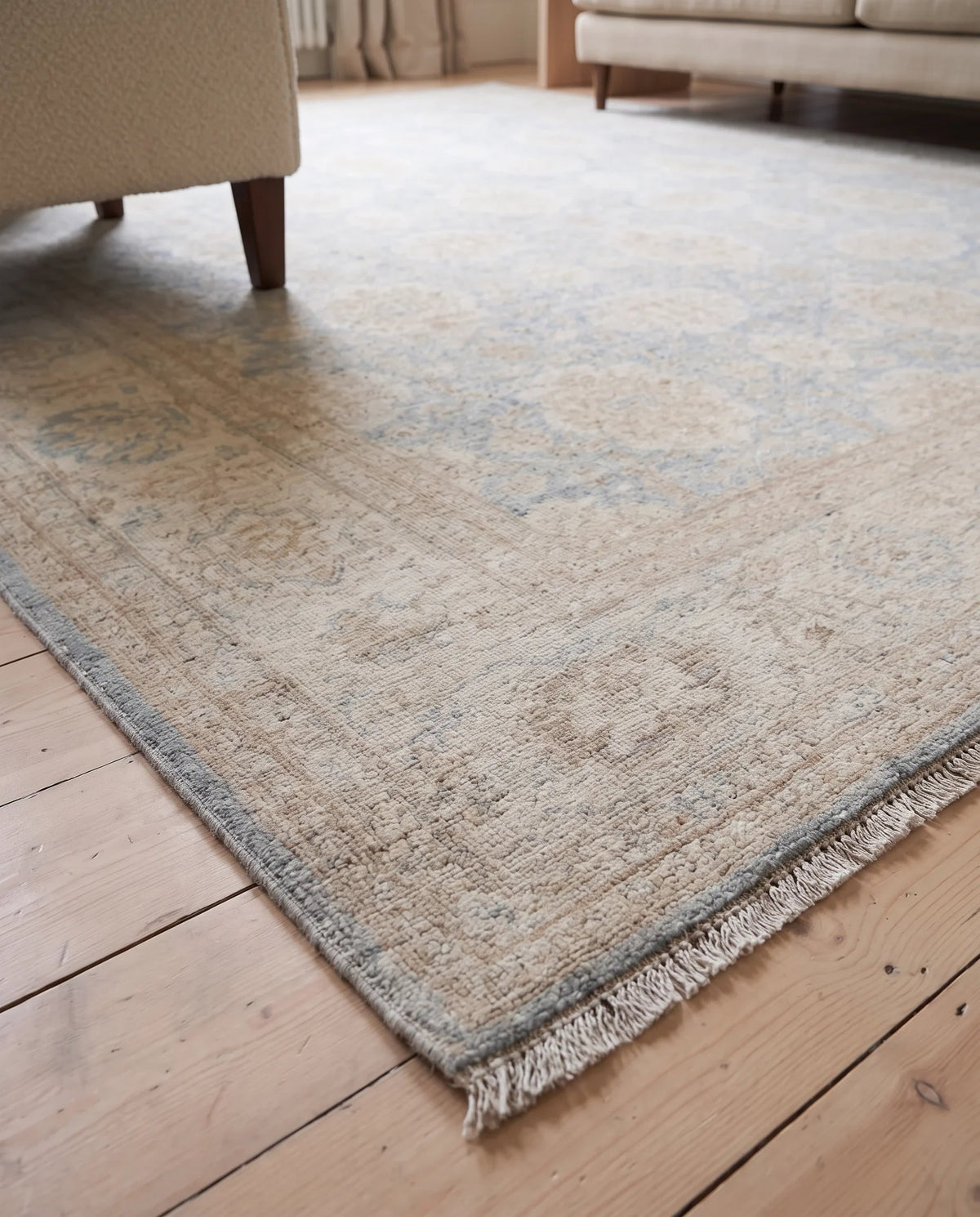 Hand-knotted Afghan Balkh rug with a fine wool pile, featuring a soft blue and beige floral pattern and a tasseled fringe.