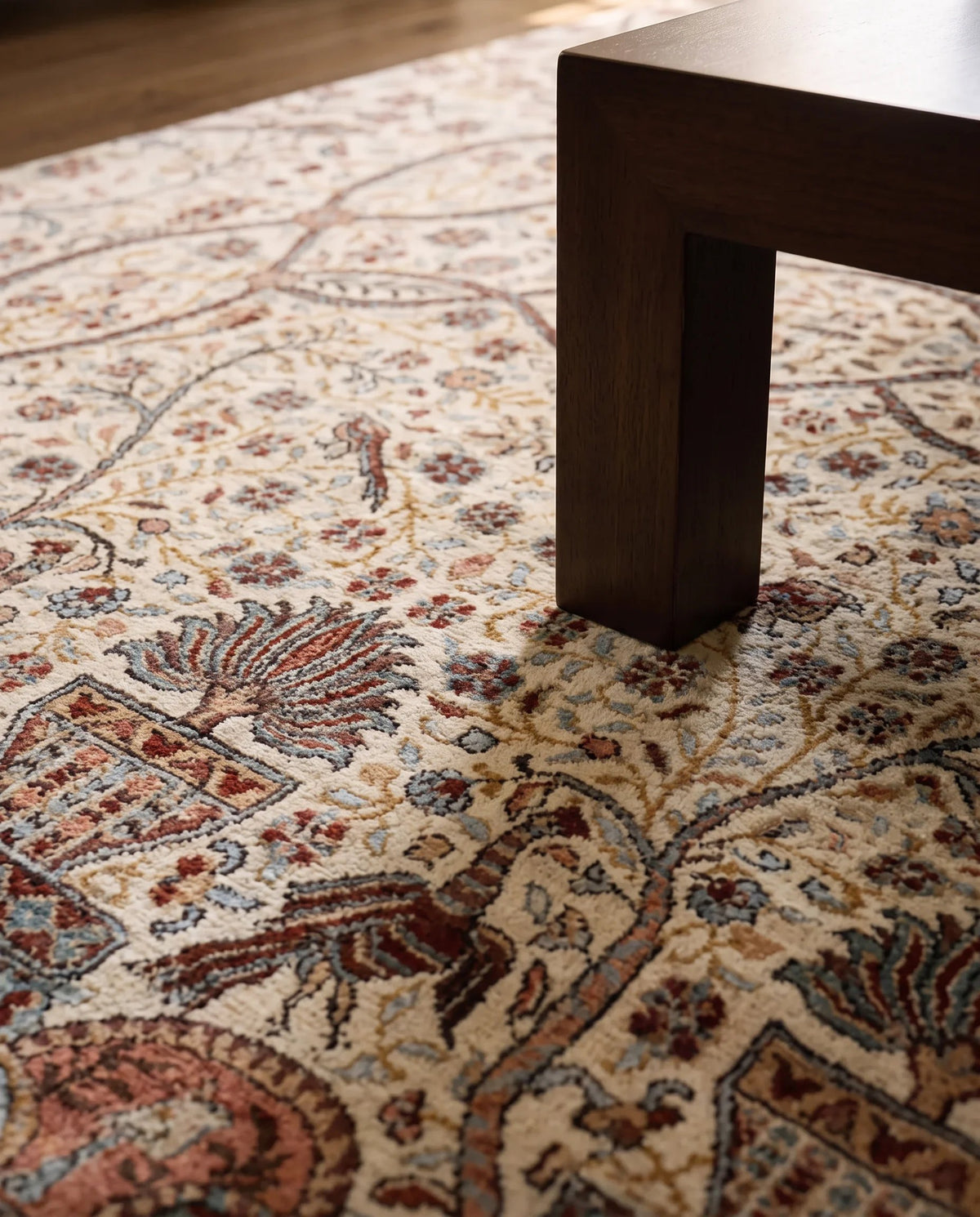 Hand-knotted Afghan Chobi rug with a cream base, intricate floral patterns in red and blue, and a low-pile wool texture.