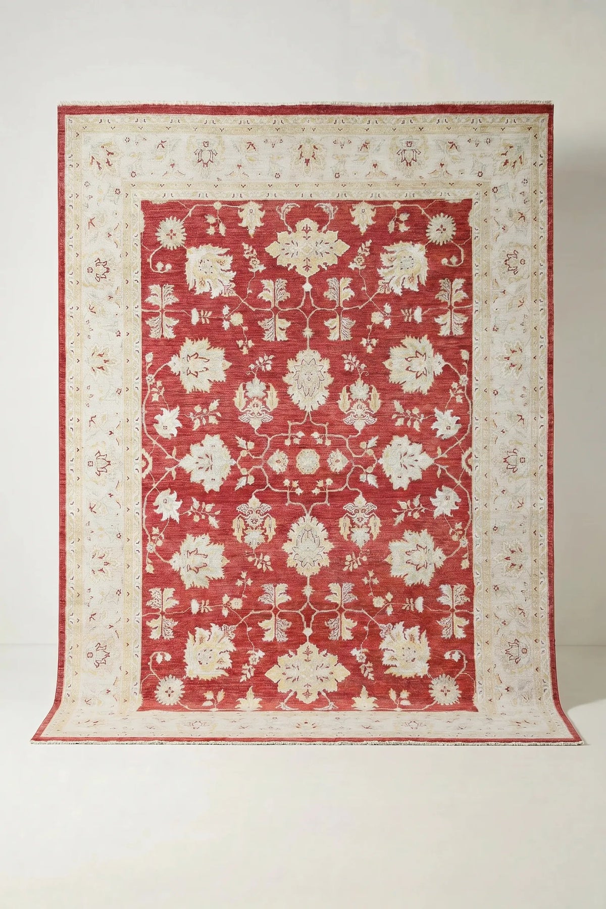 Hand-knotted Afghan Chobi rug featuring a red field with cream floral motifs and a wide, intricate border.