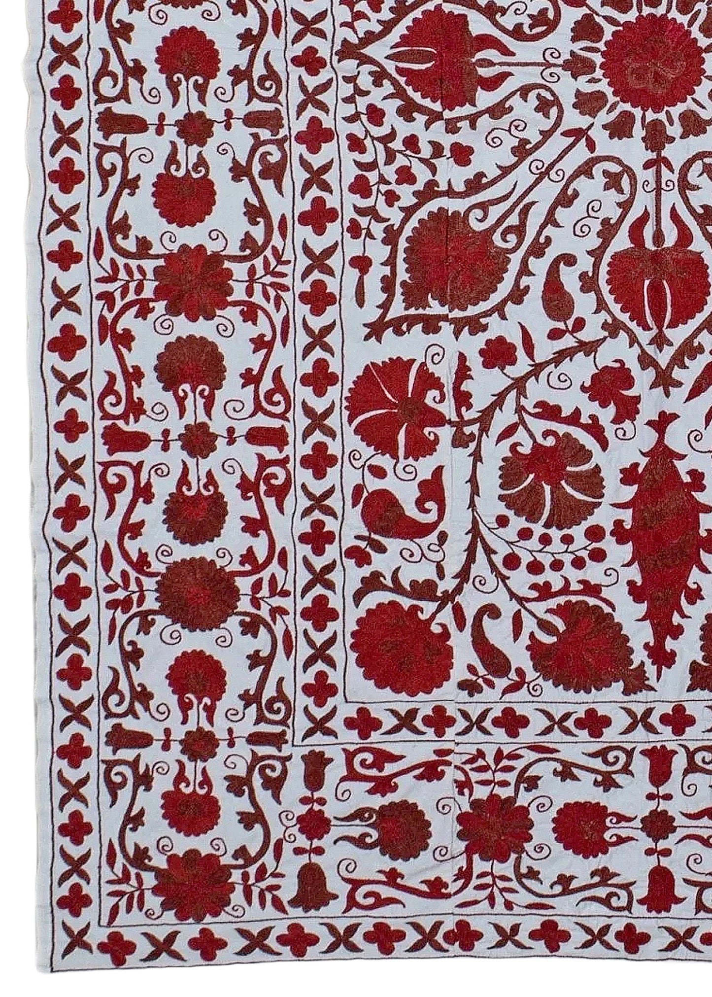 A hand-embroidered Uzbek Suzani featuring intricate red floral motifs on a white cotton base.