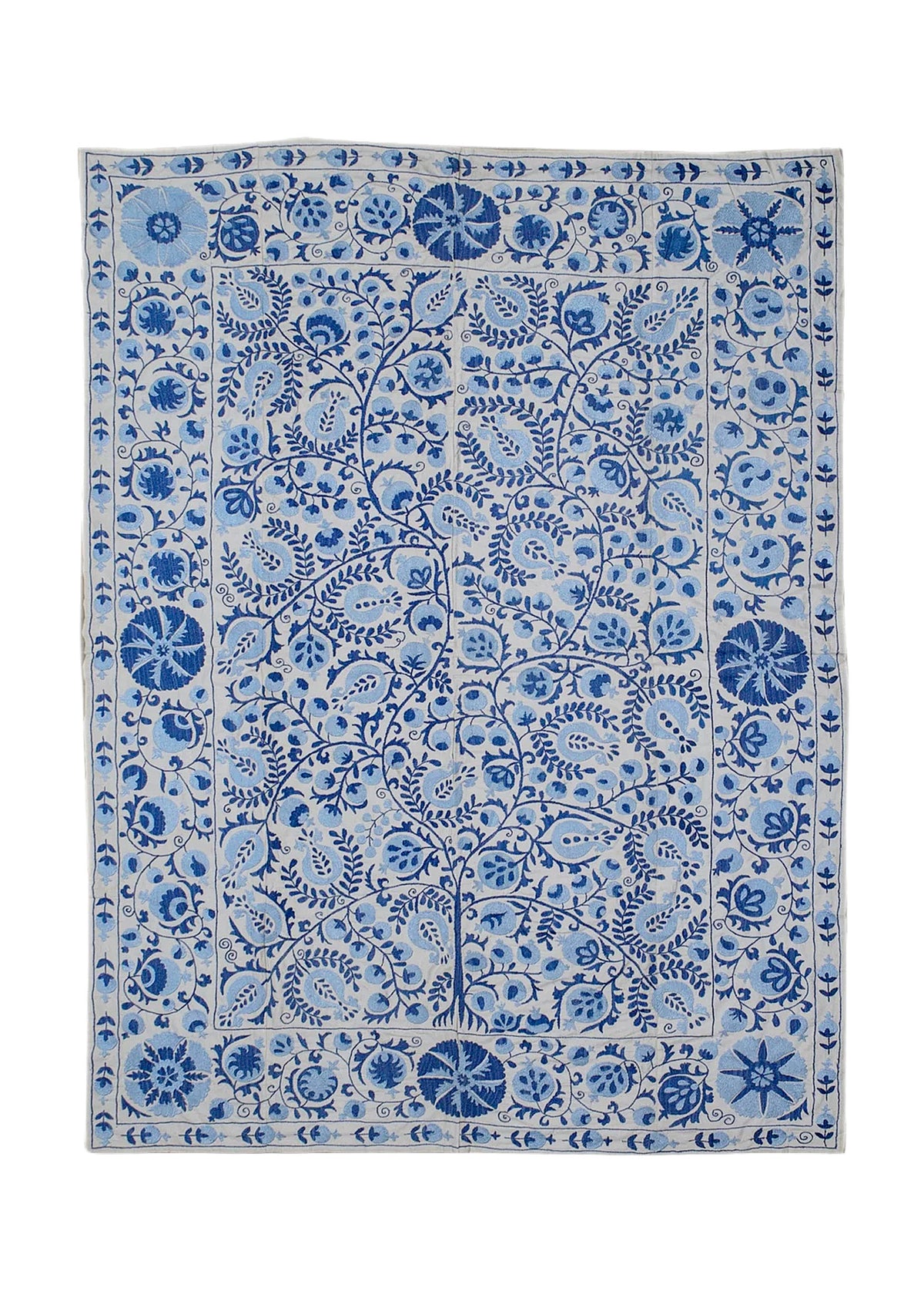 Hand-embroidered Uzbek Suzani in blue and white cotton featuring intricate floral and pomegranate motifs.