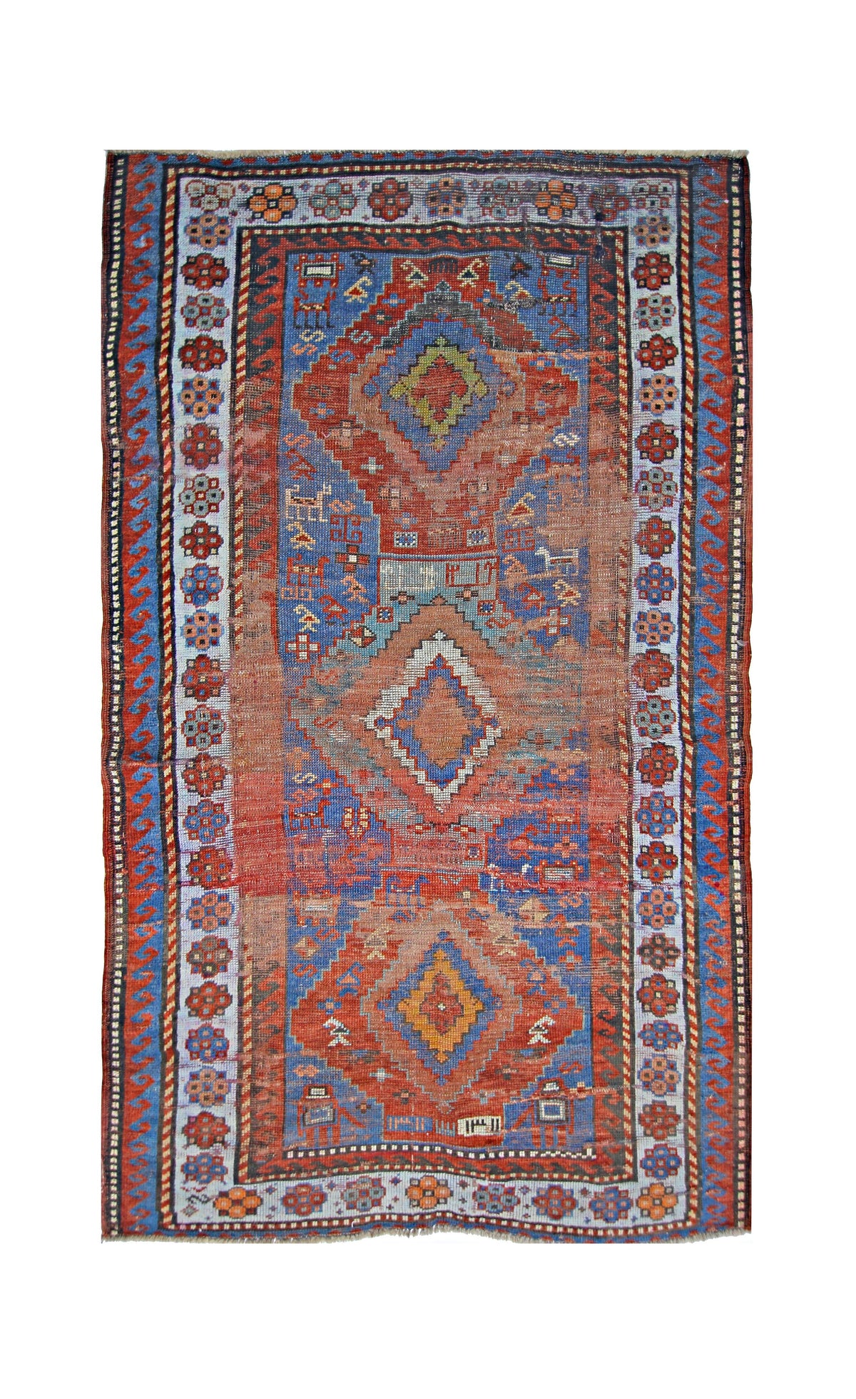 Vintage Caucasian Kazak rug featuring bold red and blue geometric medallions with intricate floral borders and fringe.