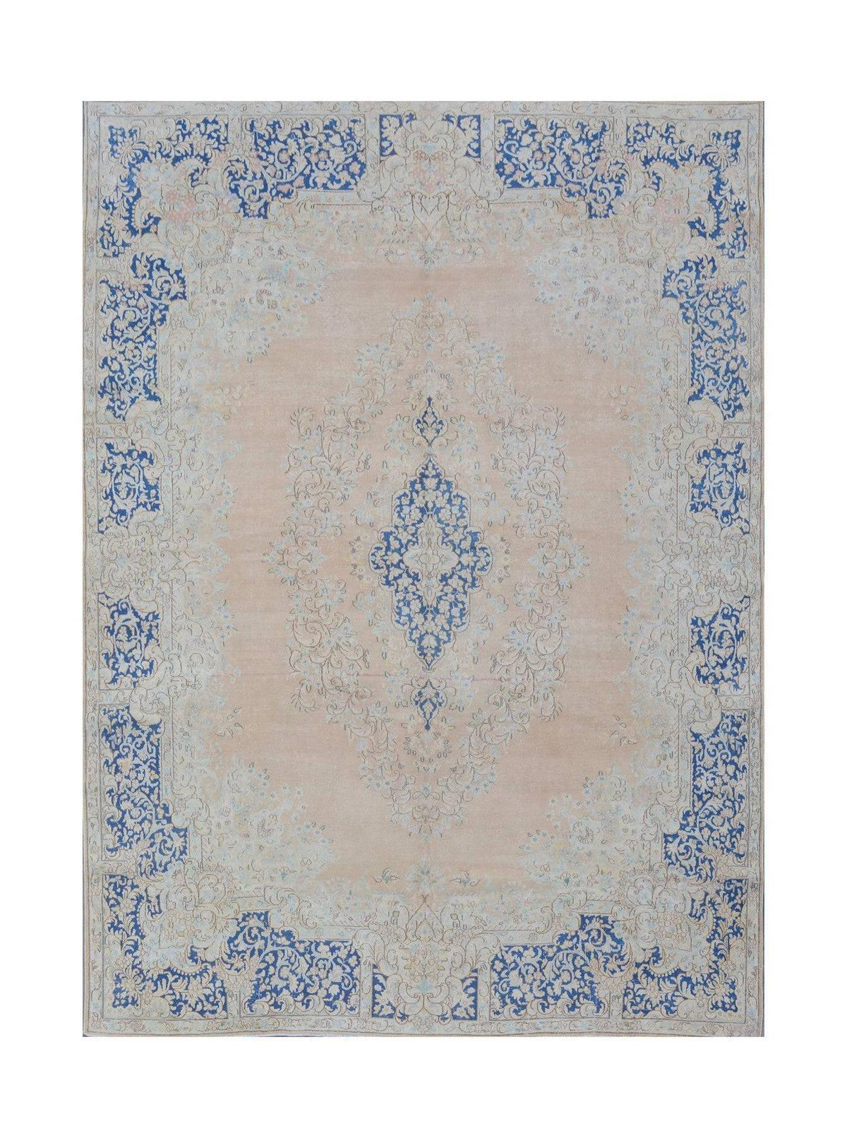 A vintage Persian Kerman rug featuring a central blue floral medallion on a soft peach background.