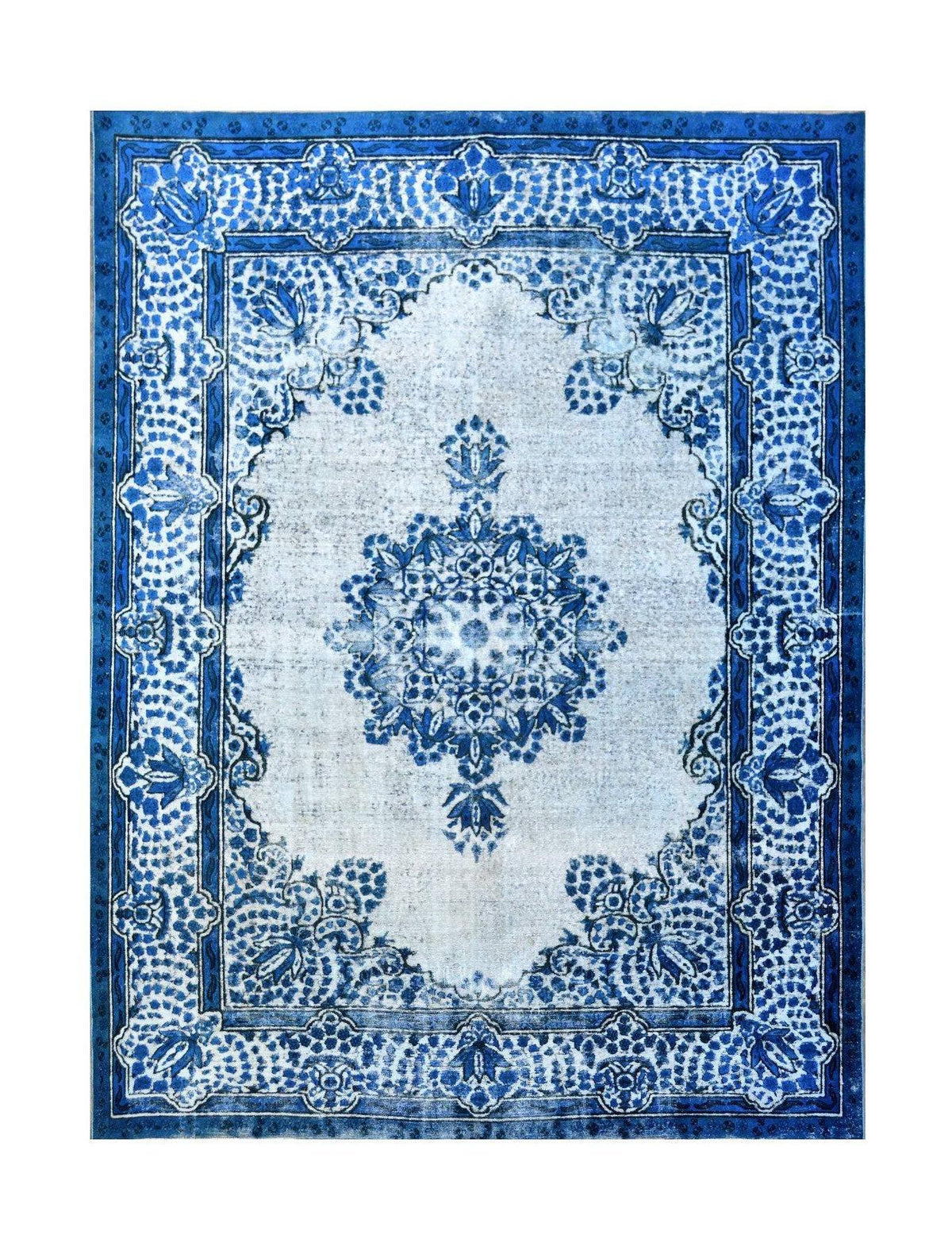 A vintage Persian Kerman rug featuring a central blue floral medallion on a light field.