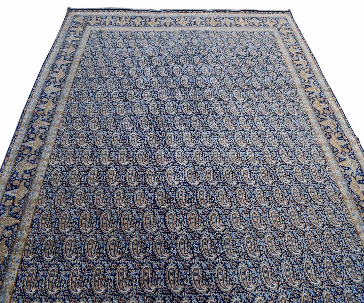 A vintage Persian Kerman rug featuring an all-over blue paisley pattern with a detailed border.