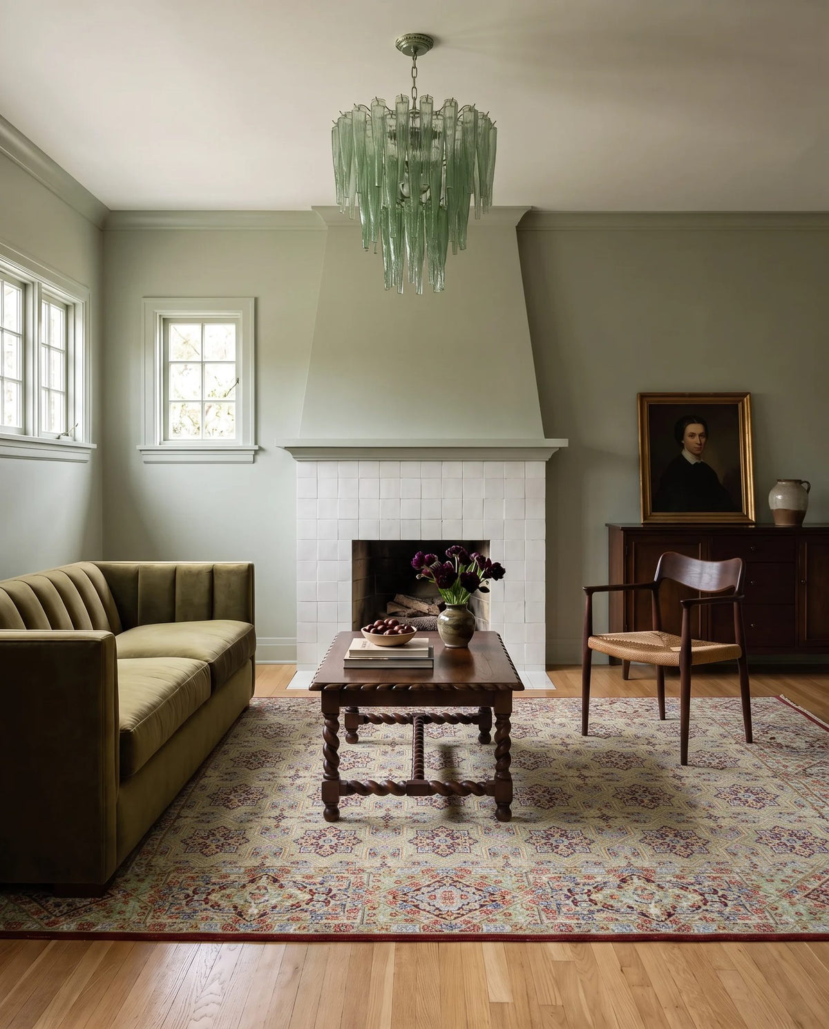 Vintage Persian Kerman wool rug with intricate floral patterns and a central medallion in a sage green living room.