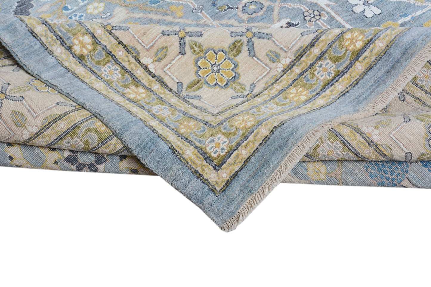 A folded Afghan Balkh rug featuring a traditional floral pattern in blue, beige, and green tones.