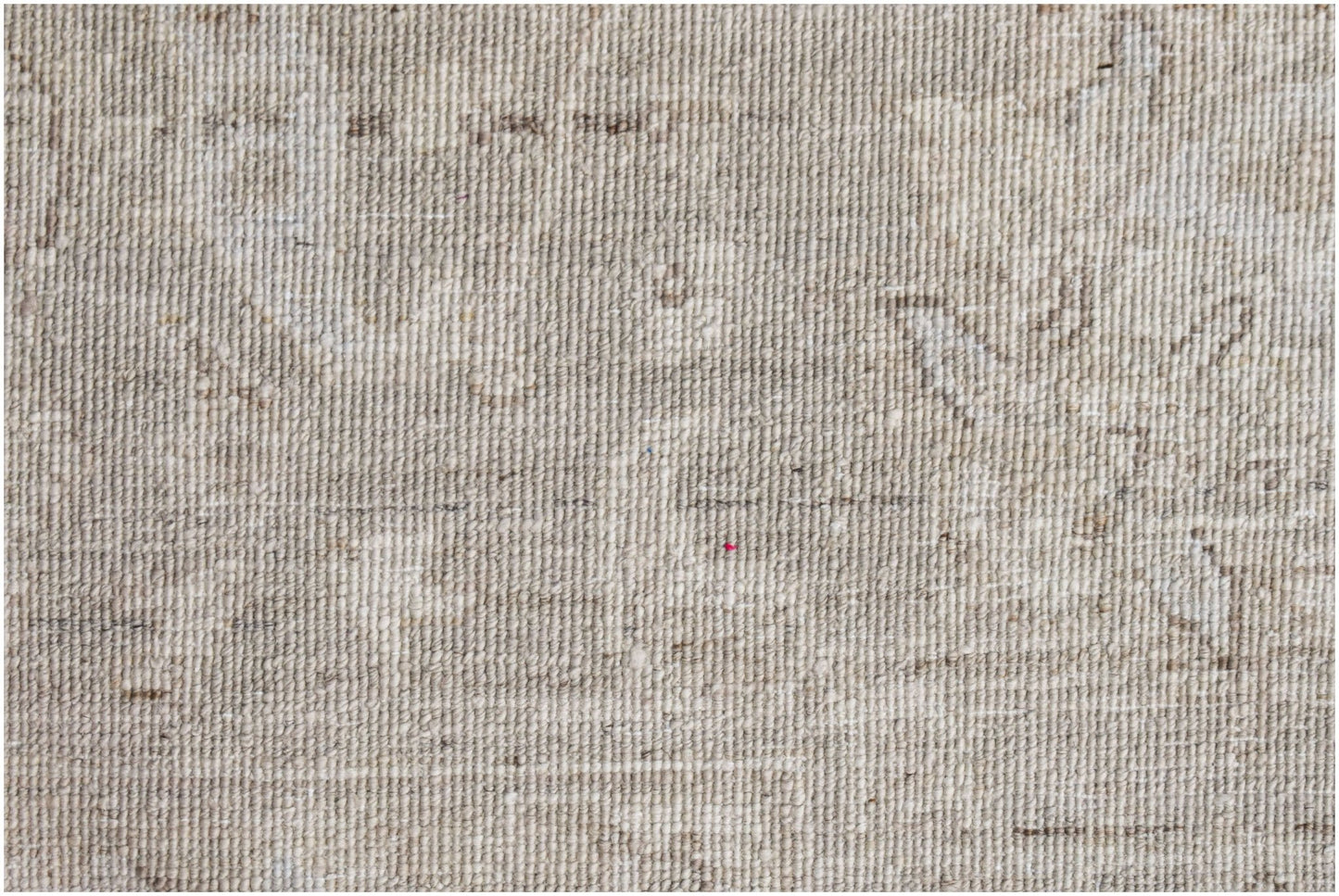 A close-up view of a handwoven Afghan Balkh rug featuring a neutral, textured wool pattern.