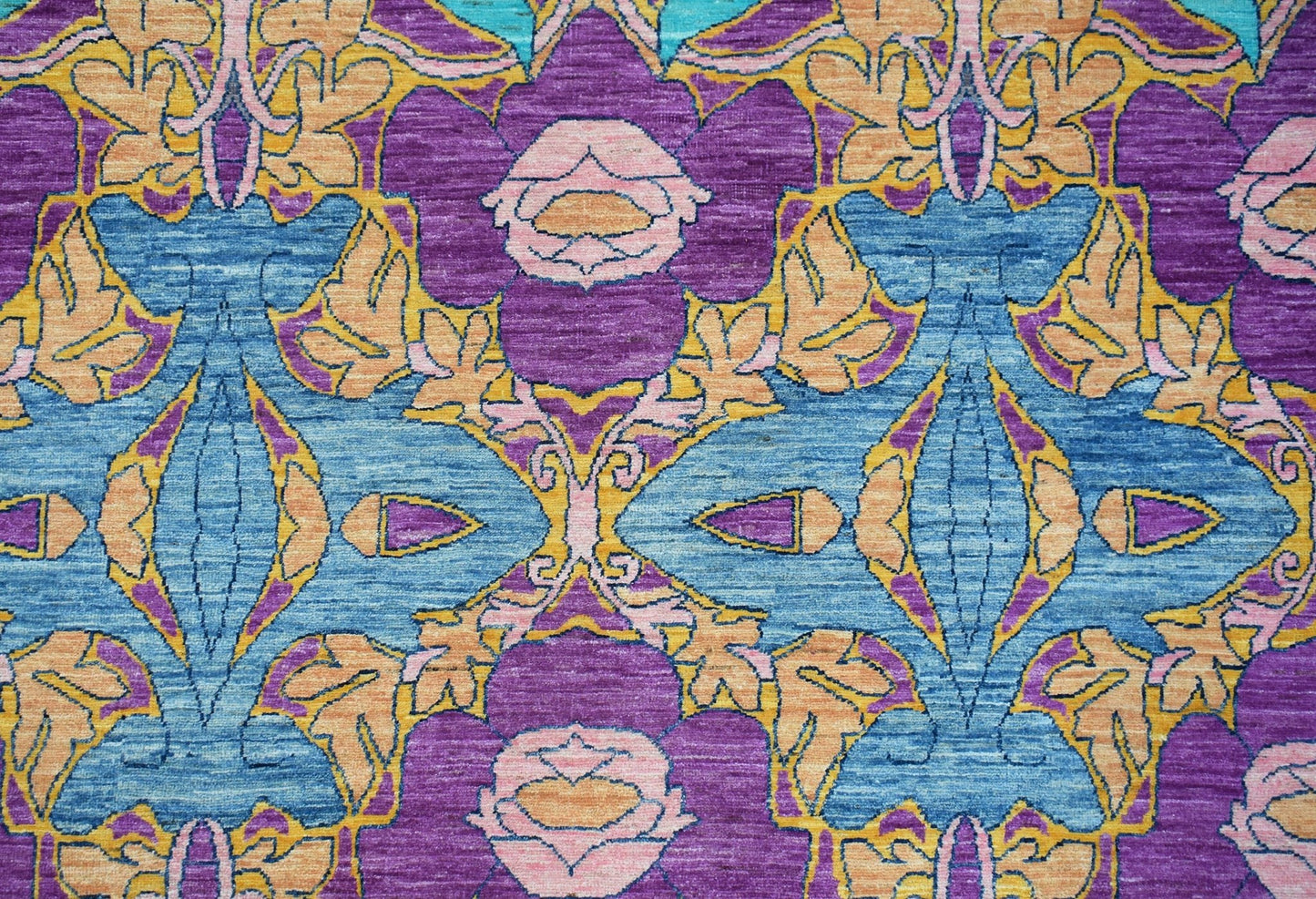 Handwoven Afghan Balkh rug featuring a symmetrical floral pattern in blue, purple, and gold tones.