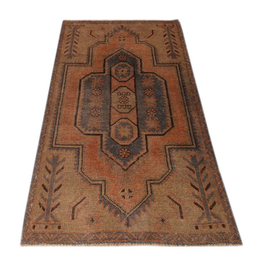 Handmade Afghan Baluch rug featuring a geometric medallion pattern in rust and charcoal tones.