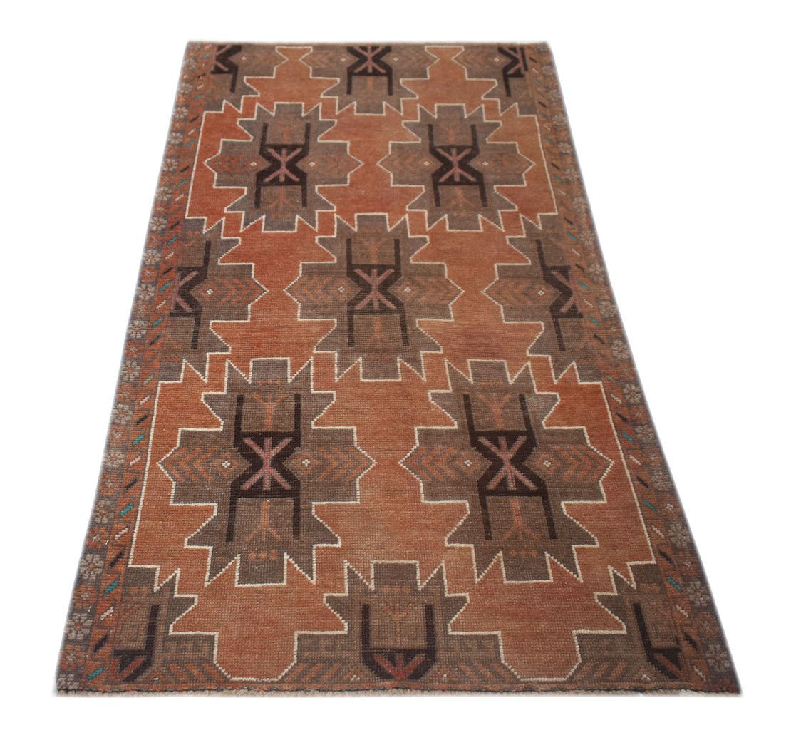 Handmade Afghan Baluch rug featuring a geometric pattern in shades of rust and brown.