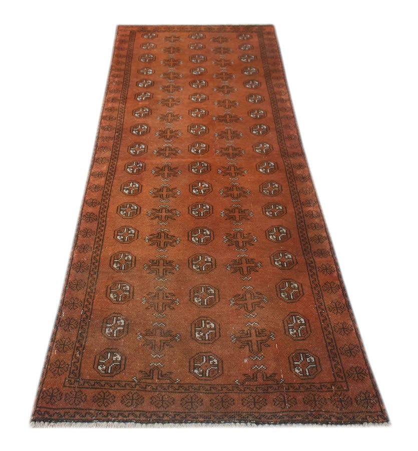 Handmade Afghan Baluch runner rug featuring a repeating geometric pattern in shades of rust red.