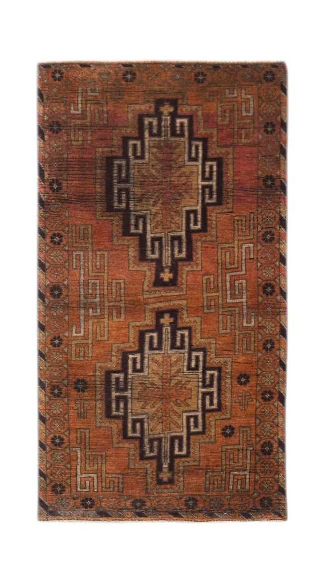 Handmade Afghan Baluch rug featuring two dark geometric medallions on a rust-colored wool field.