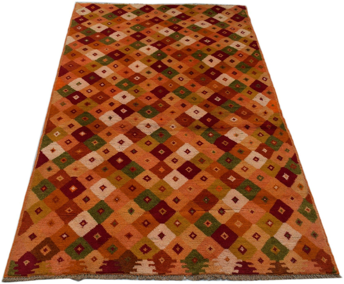 Handmade Afghan Baluch rug featuring a repeating diamond pattern in earthy tones.