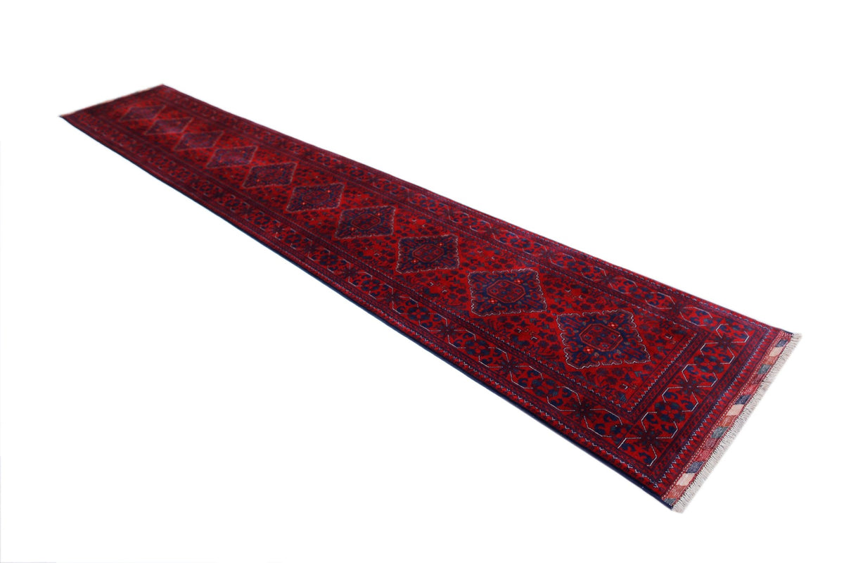 Hand-woven Afghan Biljik runner featuring deep red tones, intricate dark blue tribal medallions, and a short fringe.