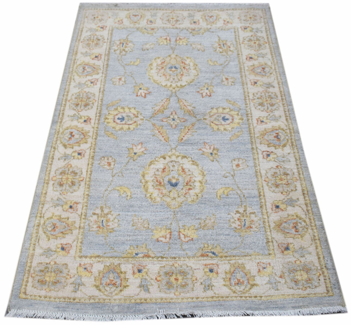 A rectangular Afghan Chobi rug featuring a traditional floral pattern in soft blue and beige tones.