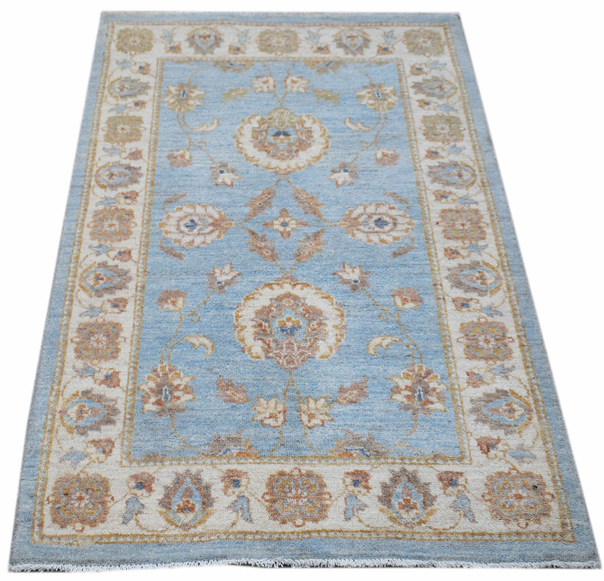 Handwoven Afghan Chobi rug featuring a traditional floral pattern in blue, beige, and brown tones.