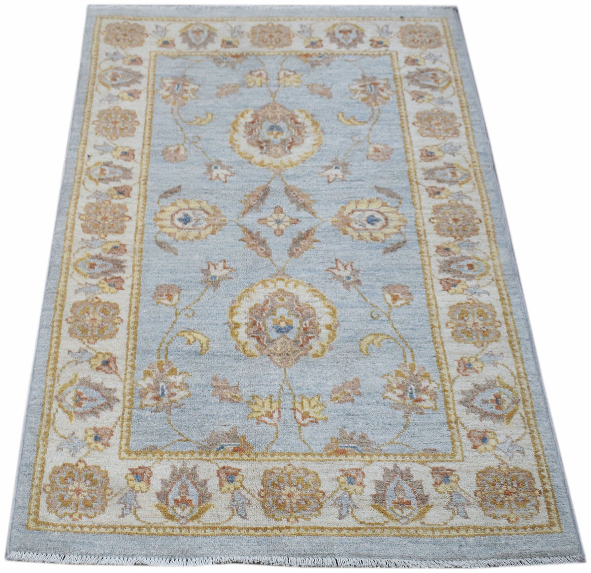 A rectangular Afghan Chobi rug featuring a light blue field with traditional floral patterns.