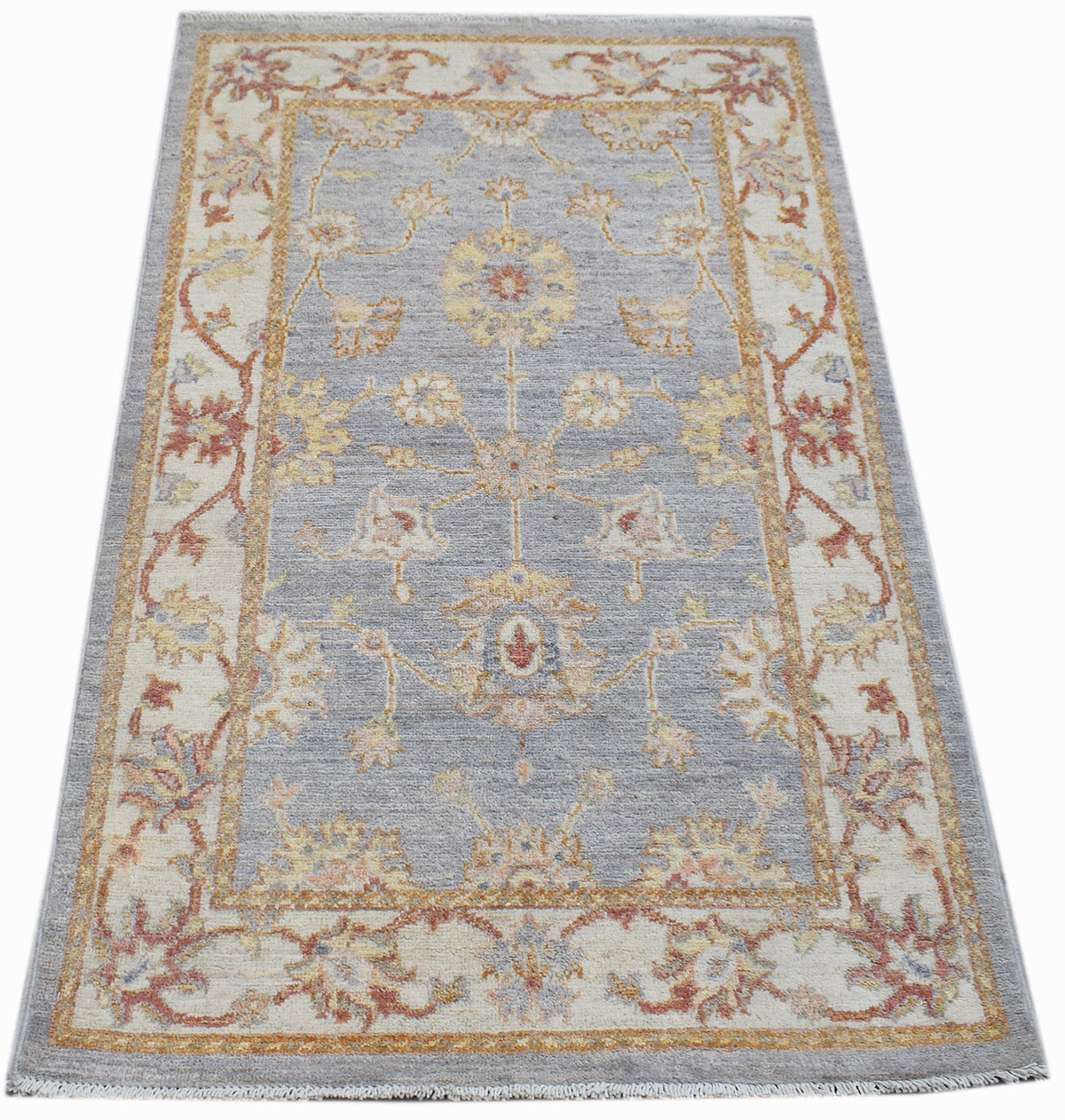 A rectangular Afghan Chobi rug featuring a traditional floral pattern in soft blue and cream tones.