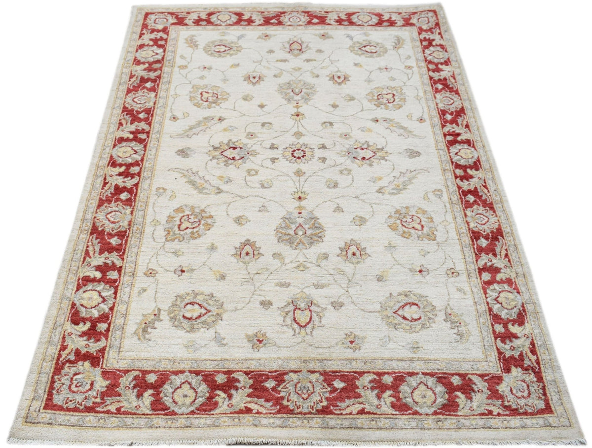 A rectangular Afghan Chobi rug featuring a cream field with floral patterns and a red border.