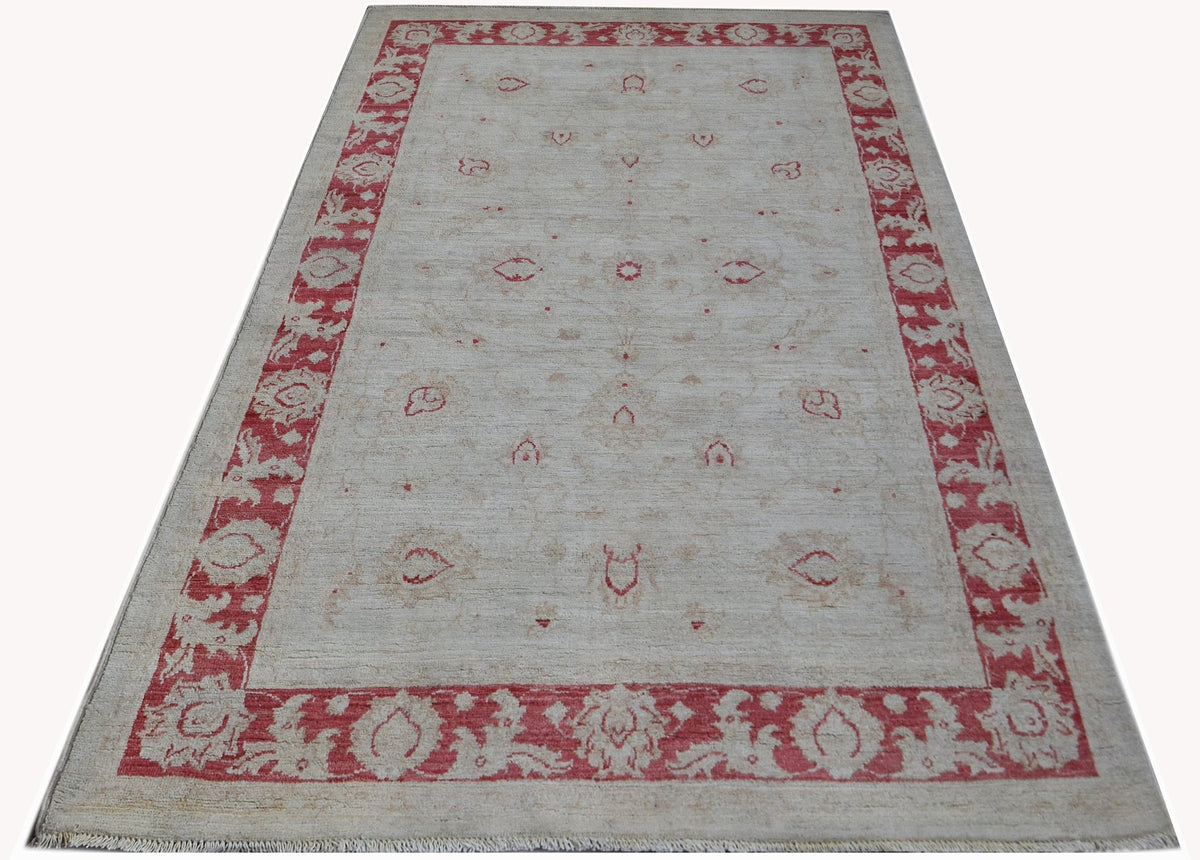 Hand-knotted Afghan Chobi rug with a cream field, red floral border, and fine wool pile.