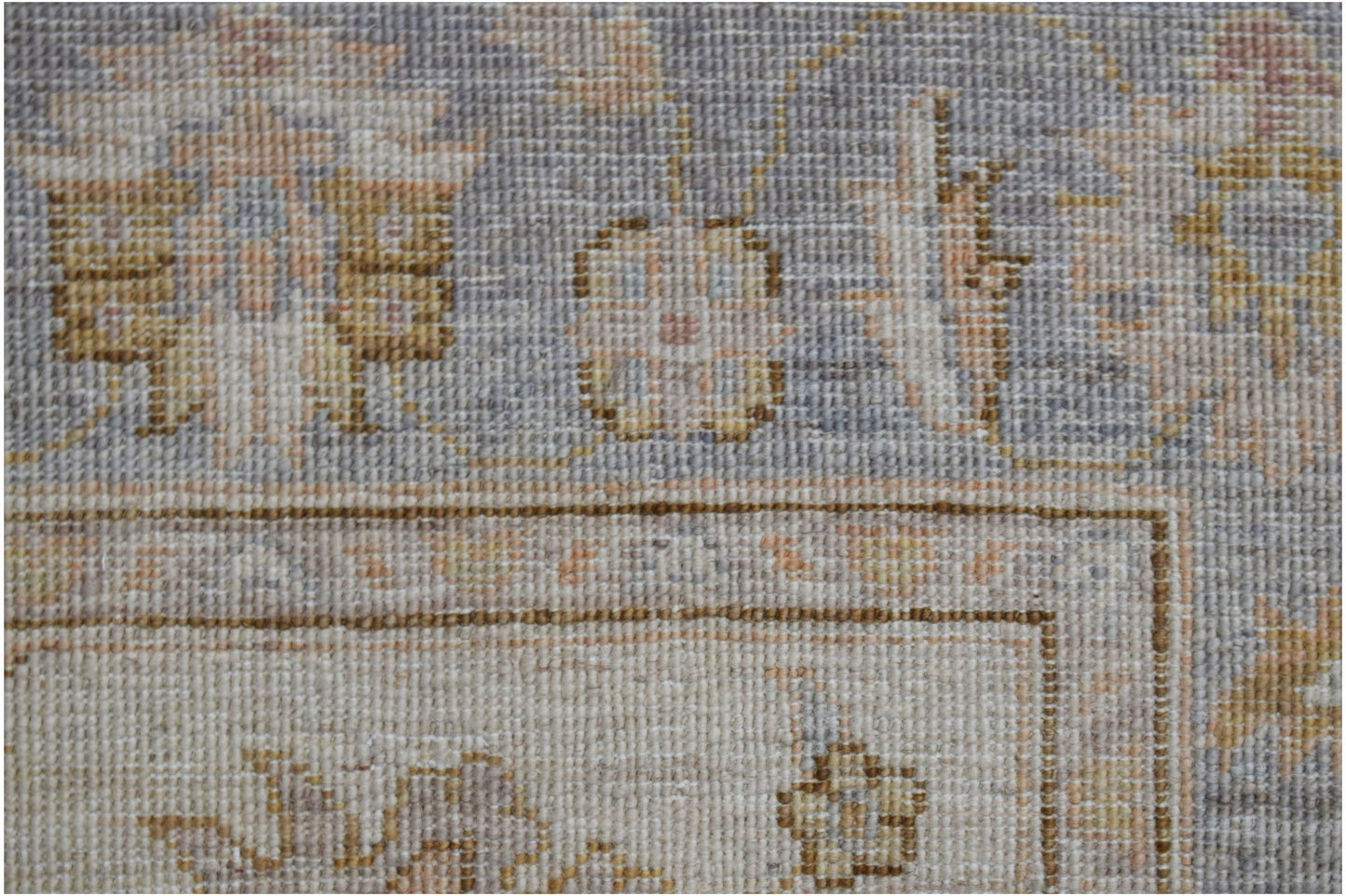 A close-up of a handwoven Afghan Chobi rug featuring traditional floral patterns in muted tones.