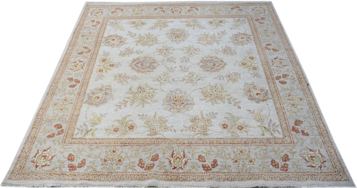 A square, handwoven Afghan Chobi rug featuring a floral pattern in soft, earthy tones.