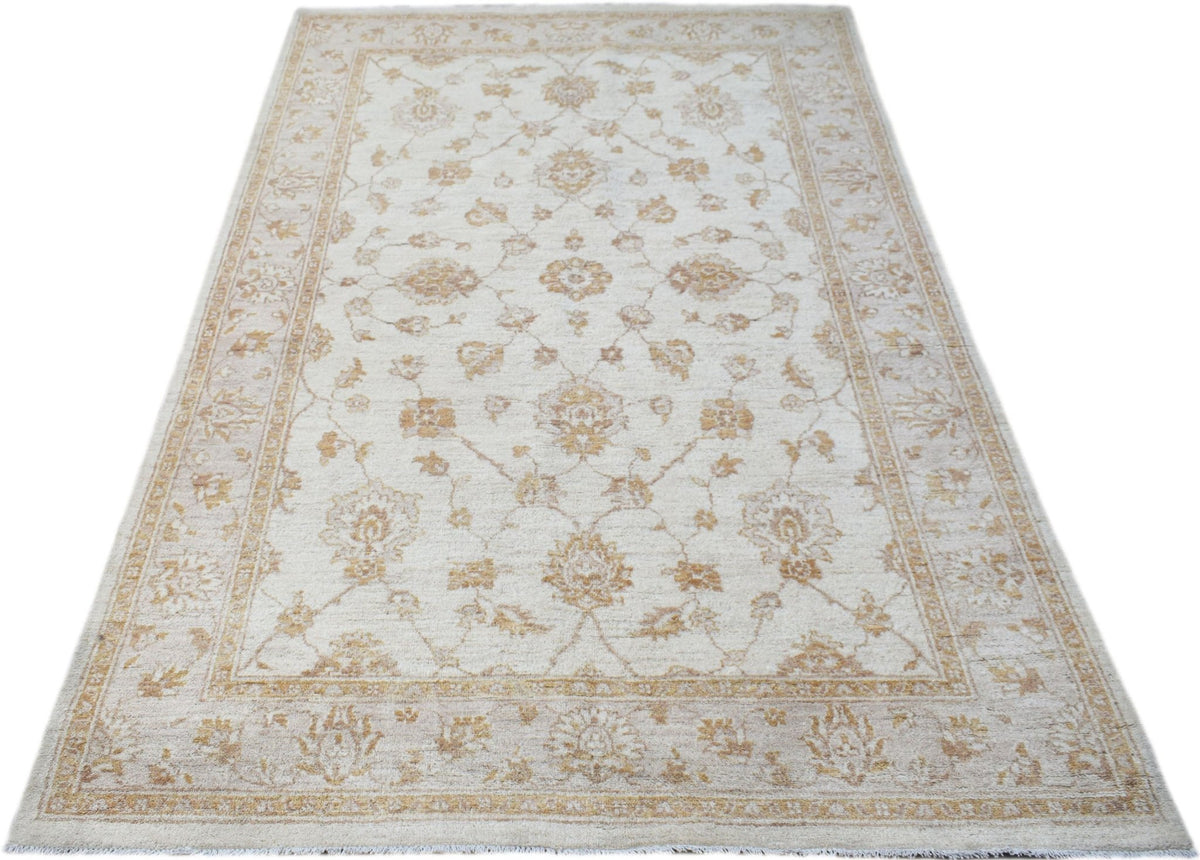 An Afghan Chobi rug featuring a traditional floral pattern in soft beige and golden wood tones.