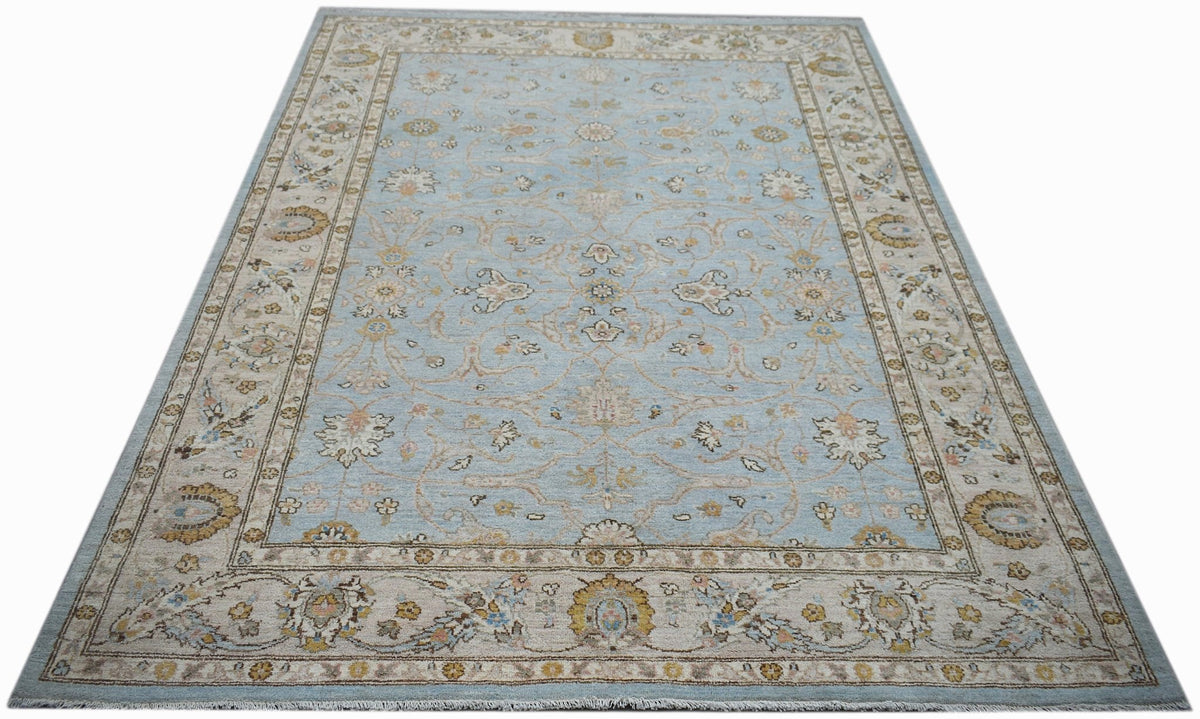 A rectangular Afghan Chobi rug featuring a light blue field with intricate floral patterns.