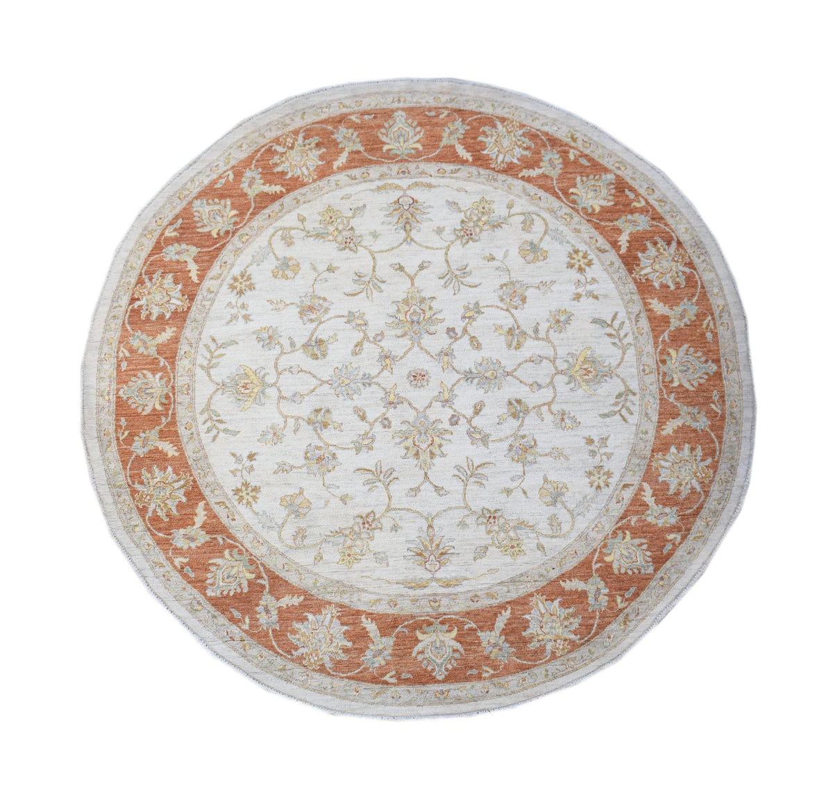 Round hand-knotted Afghan Chobi rug featuring a cream centre and terracotta floral border with intricate vine patterns.