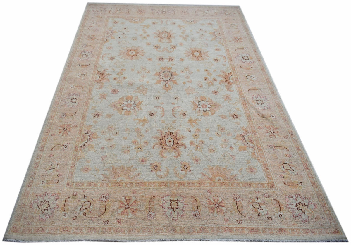 An Afghan Chobi rug featuring a traditional floral pattern in soft beige and peach tones.