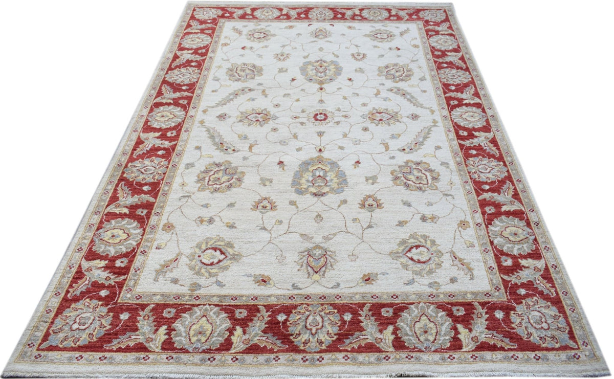 An Afghan Chobi rug featuring a floral pattern in red and beige tones on a cream background.