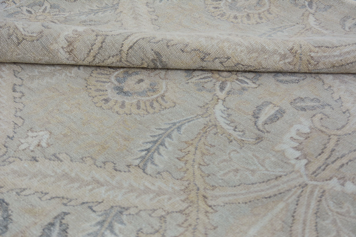 A handmade Afghan Chobi rug featuring a traditional floral pattern in neutral beige and grey tones.