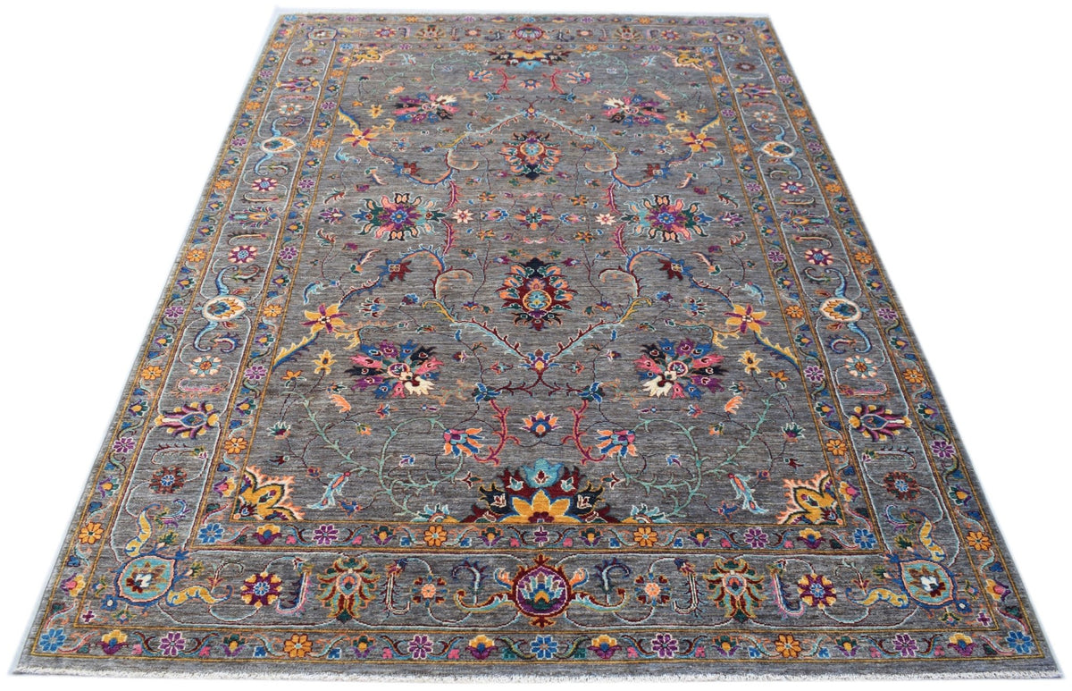 A handmade Afghan Chobi rug featuring a grey field with intricate floral patterns and a border.