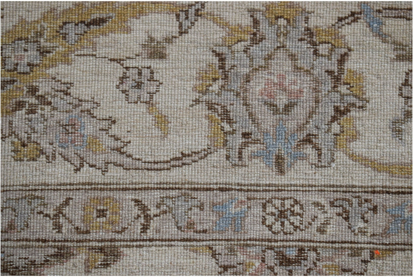 A close-up of a handwoven Afghan Chobi rug featuring traditional floral patterns in muted tones.