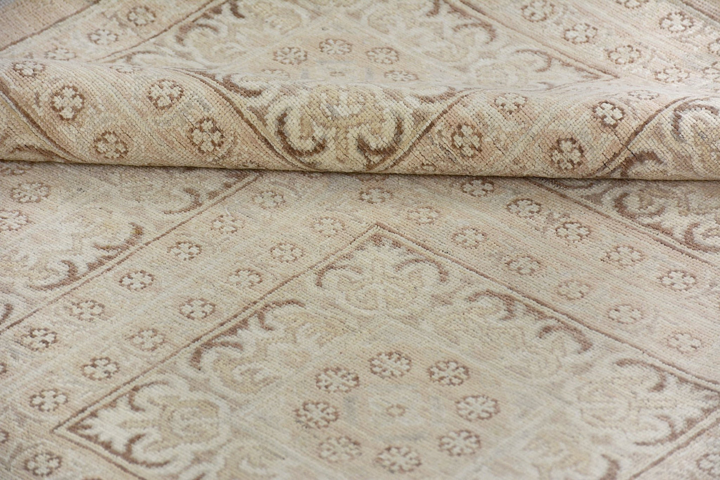 A handmade Afghan Chobi rug featuring a traditional beige and brown floral pattern.