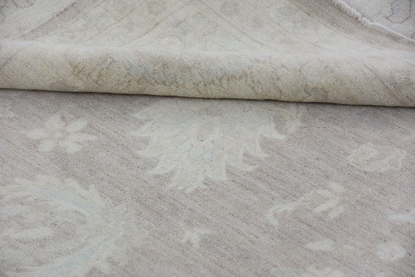 A handmade Afghan Chobi rug featuring a neutral, monochromatic floral pattern on handspun wool.