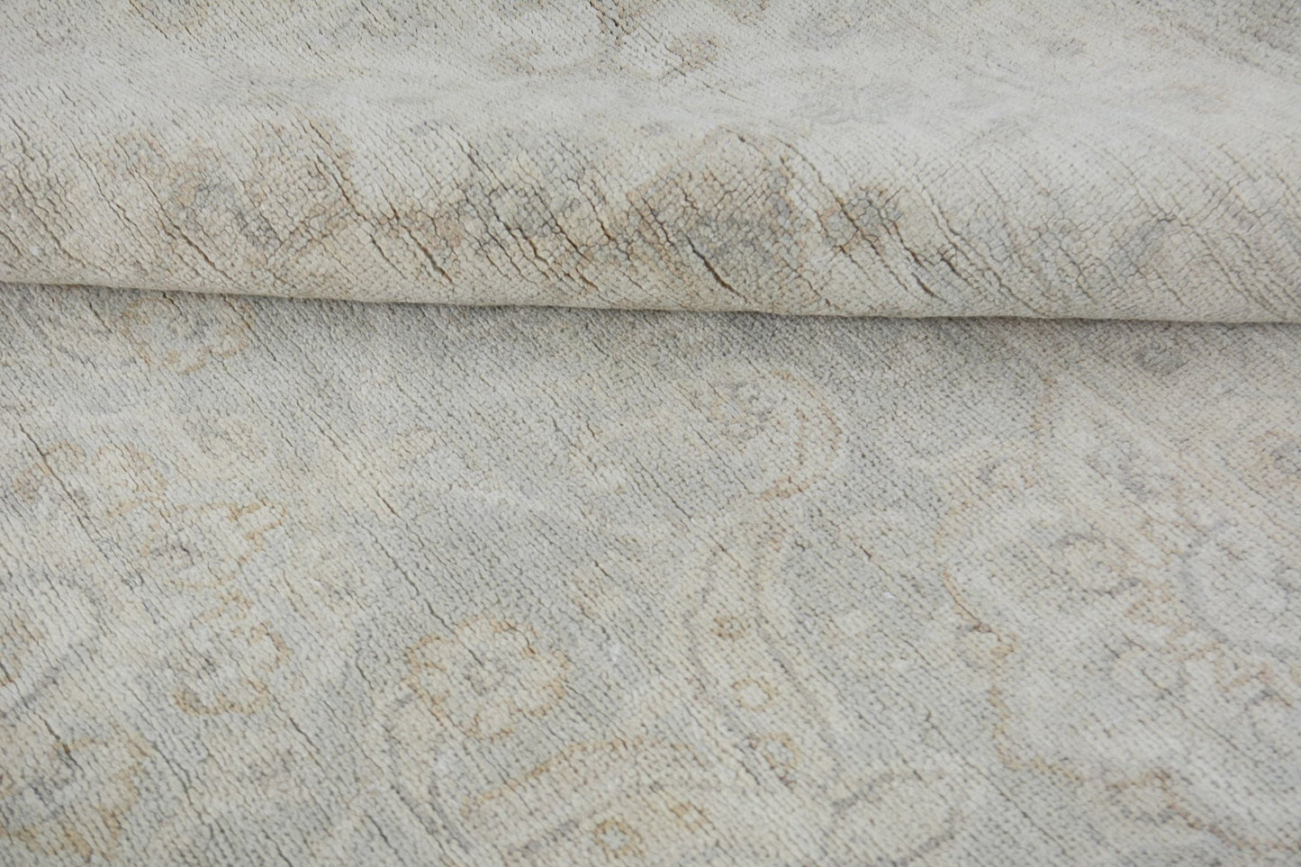 A handmade Afghan Chobi rug featuring a subtle, light-toned traditional pattern in wool.