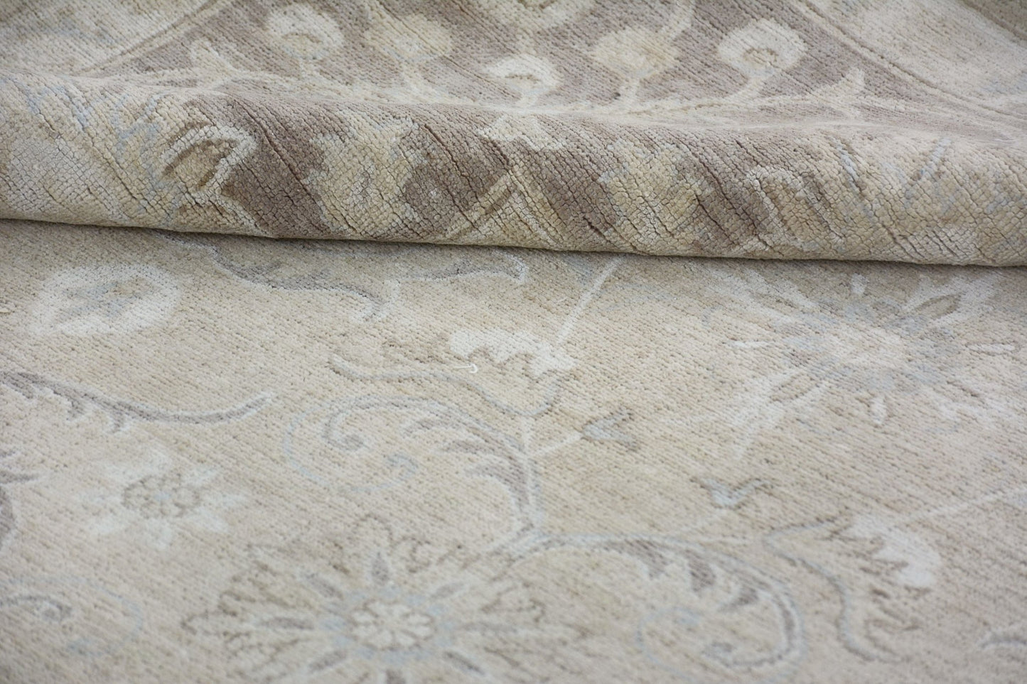 A handmade Afghan Chobi rug featuring a traditional floral pattern in neutral beige tones.