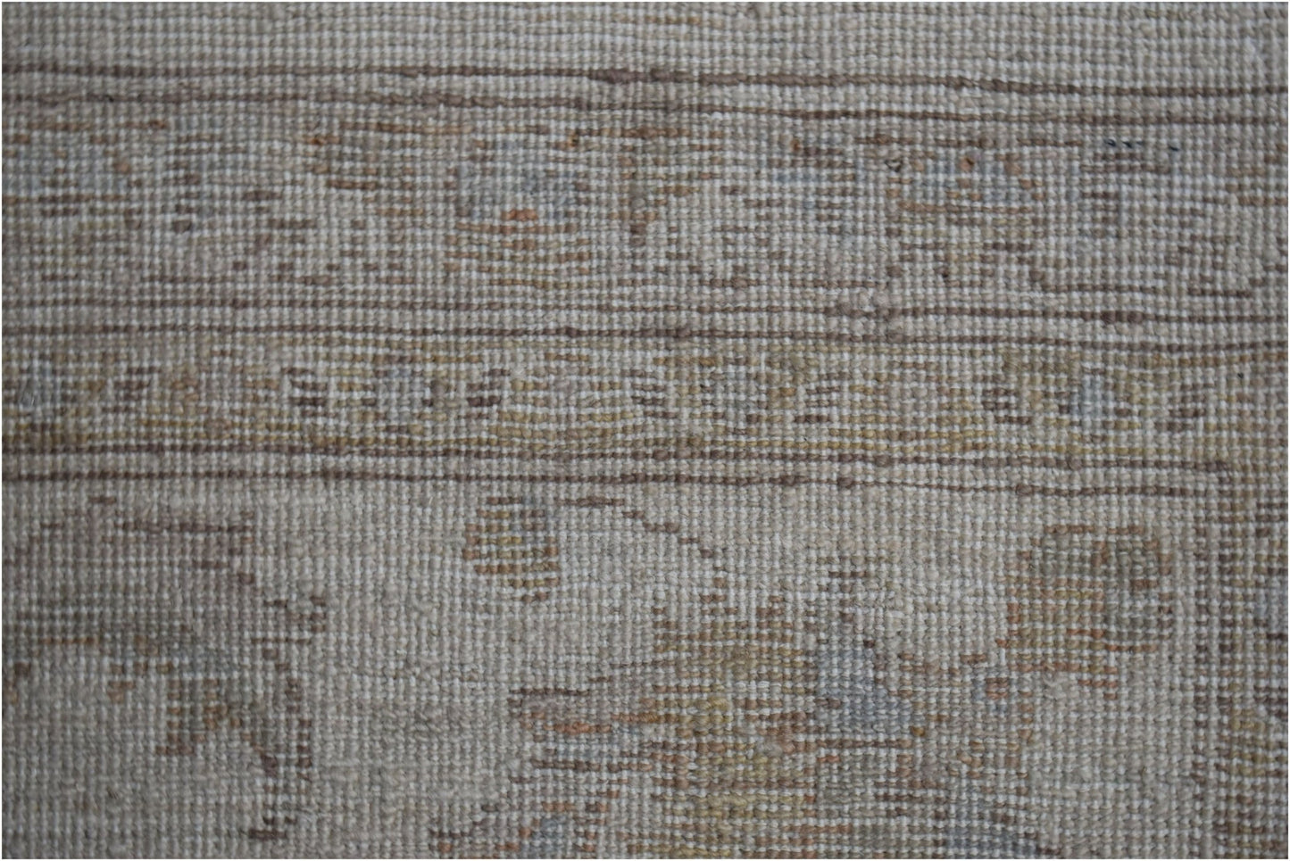 A close-up view of an Afghan Chobi rug featuring a neutral palette with subtle, earthy patterns.