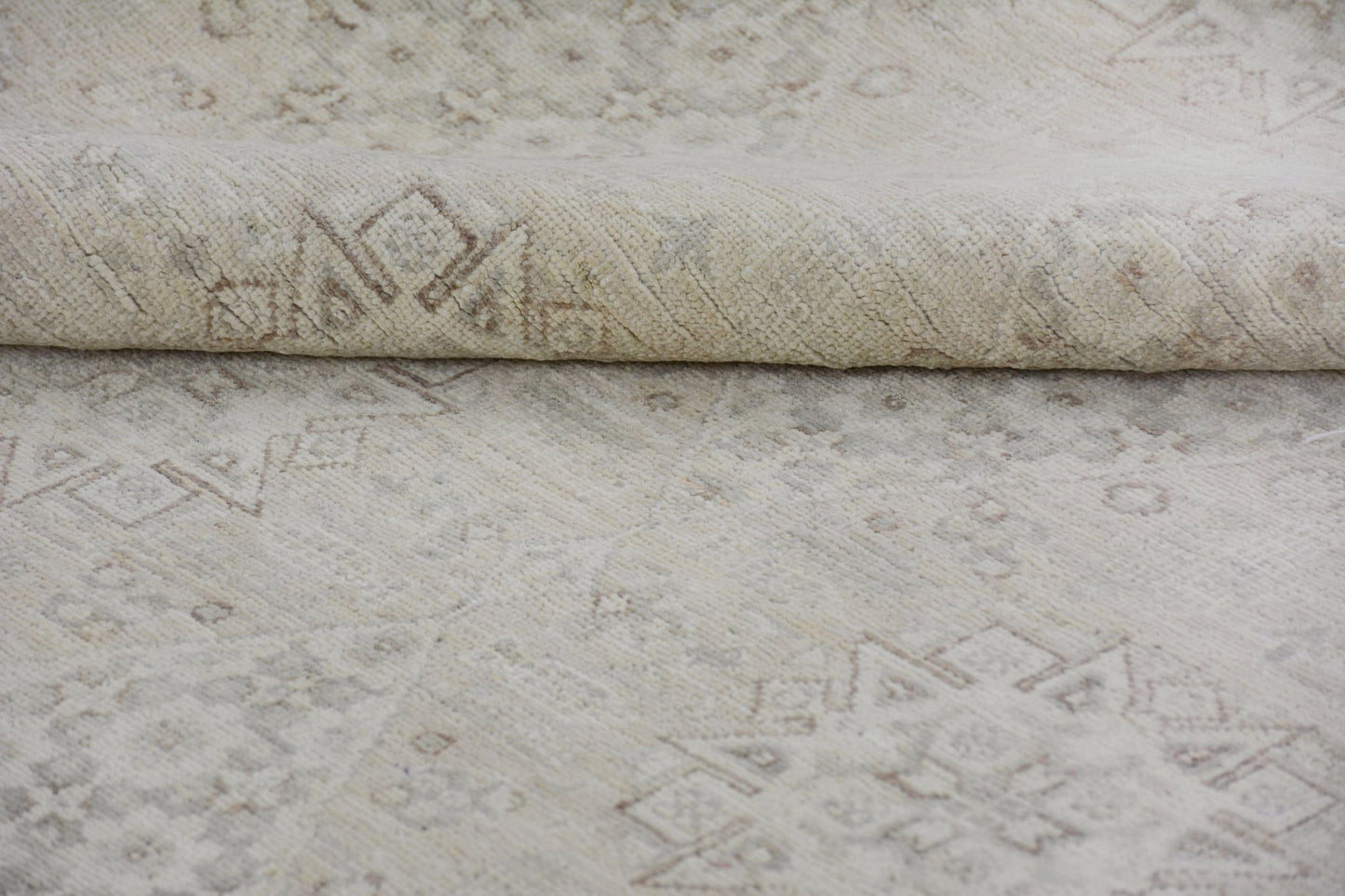 A handmade Afghan Chobi rug featuring a neutral cream palette with subtle geometric patterns.