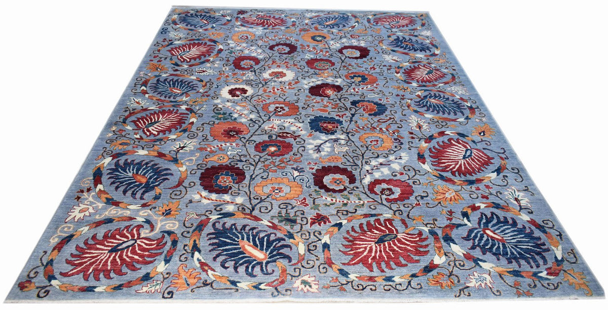 An Afghan Chobi rug featuring a traditional floral pattern in red and blue on a light blue field.