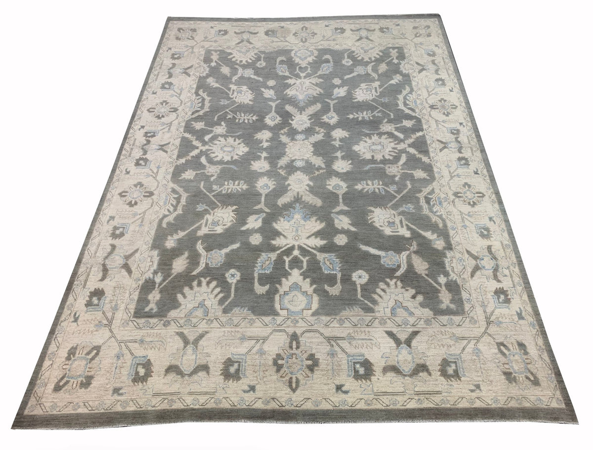 A handmade Afghan Chobi rug featuring a traditional floral pattern in grey, blue, and cream tones.