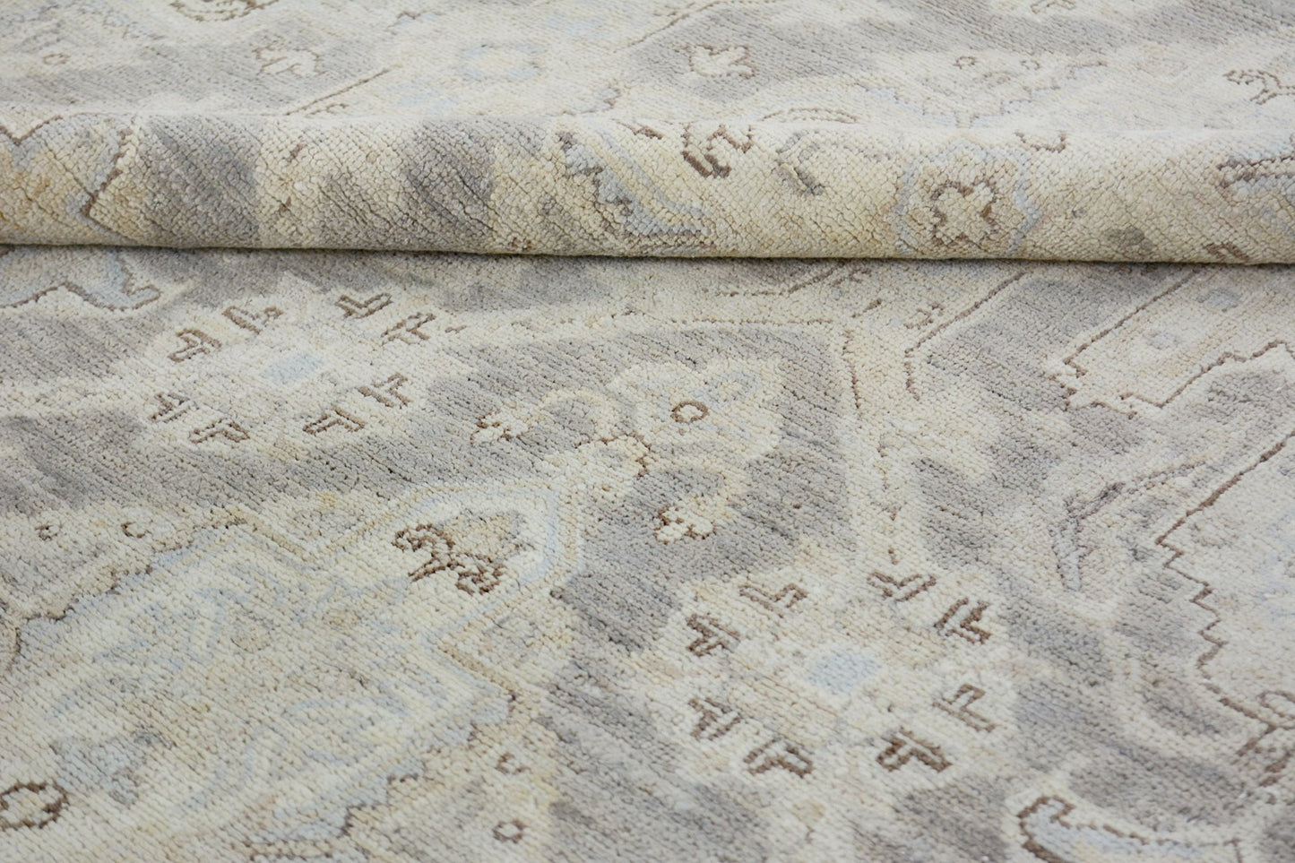 A handmade Afghan Chobi rug featuring a traditional pattern in neutral beige and grey tones.
